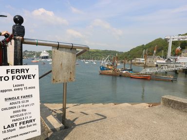 A ferry sign near a waterfront with boats and a floating dock in a harbor at The Watch Below in Polruan