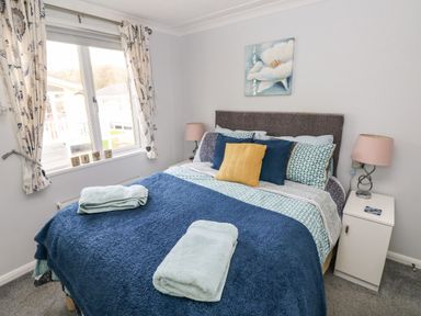 A bedroom with a bed a window side table and lamps at The Retreat Wisemans Bridge near Saundersfoot