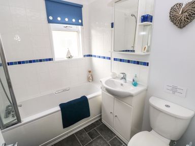 A bathroom with a bathtub toilet sink and mirror at The Retreat in Wisemans Bridge near Saundersfoot