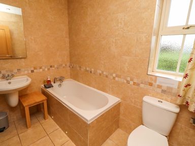 A bathroom with a bathtub, sink, and toilet at Bank Top Cottage in Embleton
