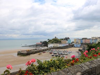 A harbor with boats on the sand and colorful buildings near the coast at 1 Beachtop Court in Tenby