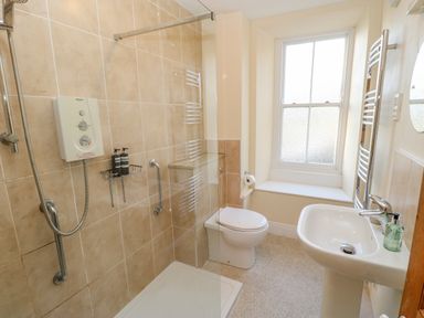 A bathroom with a walk-in shower toilet sink and a window at East Farmhouse Cottage Humshaugh near Hexham