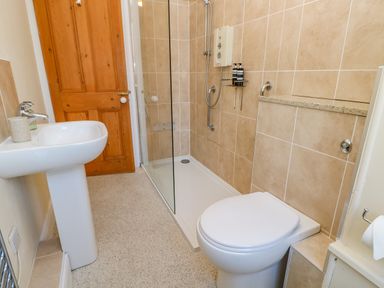 A bathroom with a sink toilet and shower at East Farmhouse Cottage in Humshaugh near Hexham