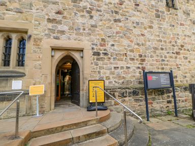 Stone building entrance with arched door and signs at Hexham Old Gaol near Hexham