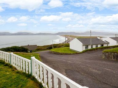 A coastal view with white cottages and a road near a beach at Rossbeigh Beach Cottage No 6 Rossbeigh near Glenbeigh County Kerry