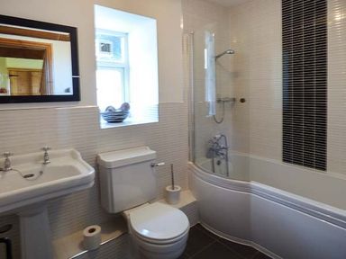 A bathroom with a sink toilet bathtub and shower at Bran Goesgoch in Holyhead