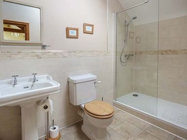 A bathroom with a sink toilet and glass shower enclosure at Bran Goesgoch in Holyhead