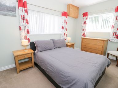 A bedroom with a bed and dresser at Dyffryn Bach in Glan-yr-afon near Corwen
