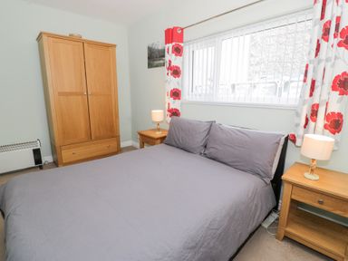 A bedroom with a bed and wooden furniture at Dyffryn Bach in Glan-yr-afon near Corwen