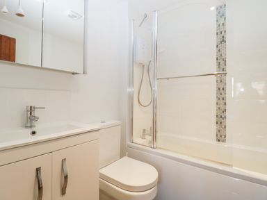 A bathroom with a sink and cabinet a toilet and a bathtub with a shower at The Stone Barn in Evercreech near Shepton Mallet