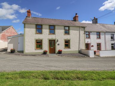 A row of two-story houses with chimneys and flower pots outside at Bank House in Capel Iwan near Newcastle Emlyn