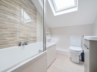 A bathroom with bathtub toilet sink and skylight window at Maple - Woodland Cottages in Bowness-on-Windermere