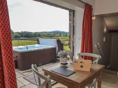 A seating area with a hot tub and view of the landscape at Acorn in Bowness-on-Windermere