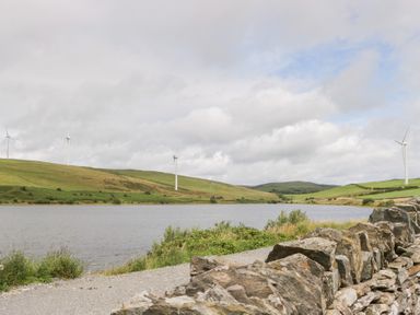 A landscape with wind turbines and a lake at Ash Lodge Pennington near Ulverston