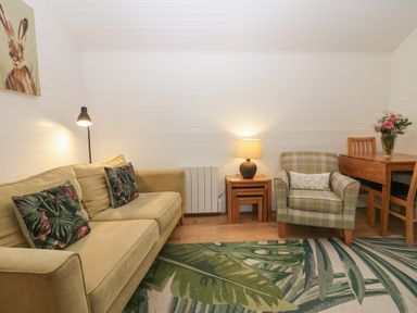 A living room with a sofa and armchair at Ash Lodge in Pennington near Ulverston
