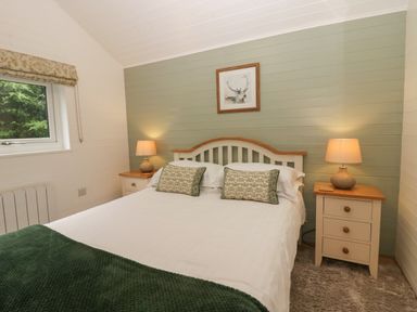 A bedroom with a bed and nightstands at Ash Lodge Pennington near Ulverston