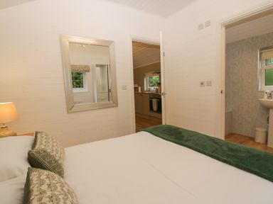 A bedroom with a bed and a mirror at Ash Lodge in Pennington near Ulverston