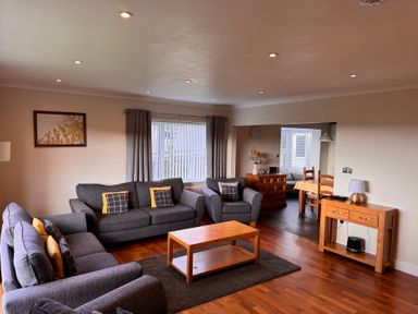 A living room with sofas and a coffee table at Rhos Helyg near Penysarn Amlwch