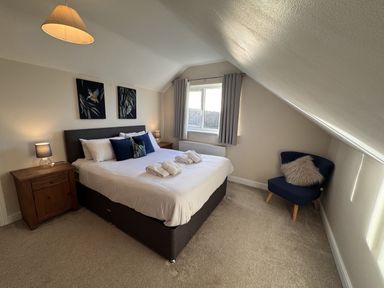 A bedroom with a bed and nightstand at Rhos Helyg Penysarn near Amlwch