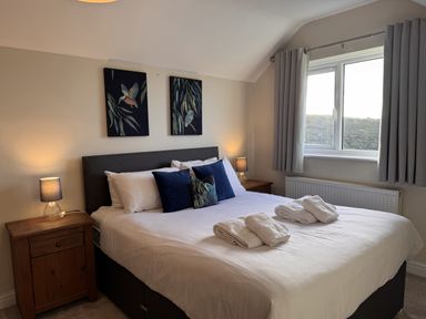 A bedroom with a bed and bedside tables at Rhos Helyg Penysarn near Amlwch