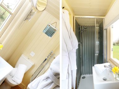 A bathroom with a toilet towel radiator and towels beside a shower with corrugated metal walls a sink with a towel and flower at Willow Burlawn near Wadebridge