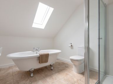 A bathroom with a clawfoot bathtub a toilet and a glass shower enclosure at Rocky Close in St Ives