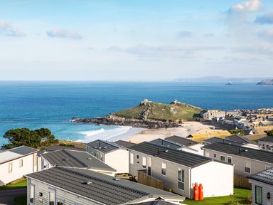 A coastal area with holiday cabins near the beach and ocean at Chy Lowen in St Ives