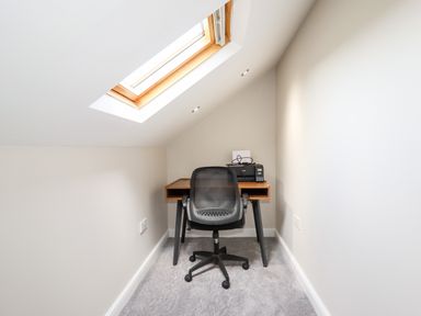 A small office space with a desk, office chair, printer, and skylight window at 4 Bodnant Road in Rhos-On-Sea
