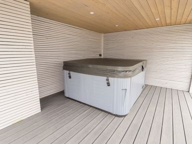 A covered hot tub in a wooden paneled room with wood flooring at 4 Bodnant Road in Rhos On Sea