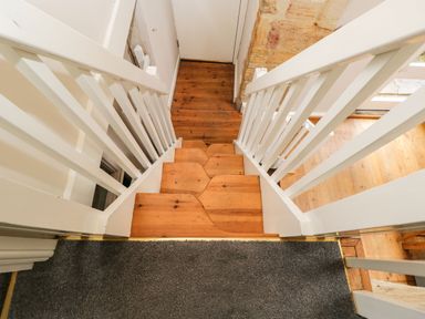 A wooden staircase with white railings and gray carpet at the top at Bower Coach House in Bower Hinton near Martock