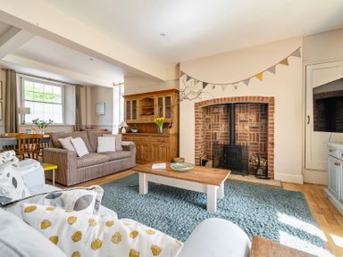 A living room with a fireplace and seating at East Wing in Crewkerne