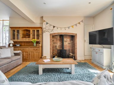 A living room with a fireplace and television at East Wing in Crewkerne