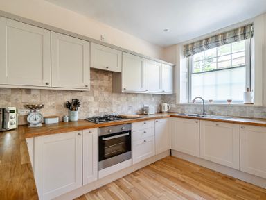 A kitchen with cabinets and stove at East Wing in Crewkerne