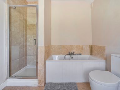A bathroom with a shower, bathtub, and toilet at East Wing in Crewkerne
