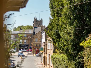 A view of a clock tower and street scene at East Wing in Crewkerne