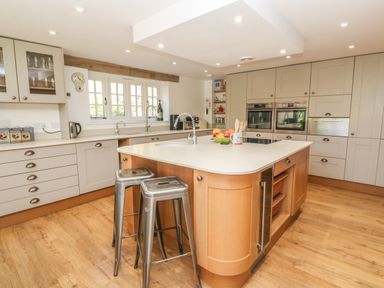 A kitchen with a central island and two metal stools Ros Vale St Buryan