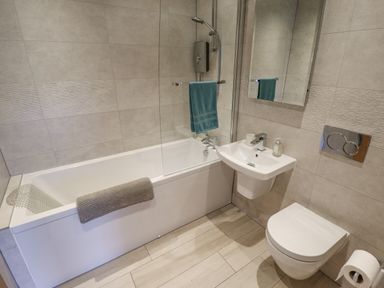 A bathroom with a bathtub shower sink toilet and towels at Lily-pad Lodge in Thorpe-on-the-Hill
