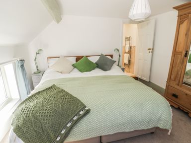 A bedroom with a double bed pillows and green lamps at Town Mill in Bewdley
