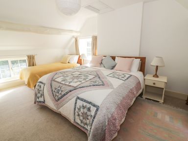 A bedroom with two beds a bedside table with a lamp and windows at Town Mill in Bewdley