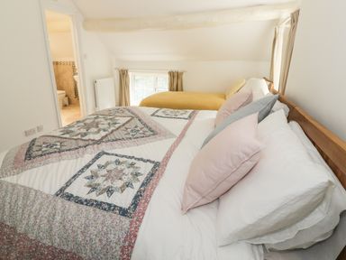 A bedroom with a double bed and a single bed near a window at Town Mill in Bewdley
