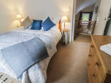 A bedroom with a bed with cushions and lamps on side tables at Town Mill in Bewdley