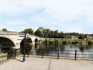A stone bridge over a river with trees and buildings in the background at Town Mill in Bewdley