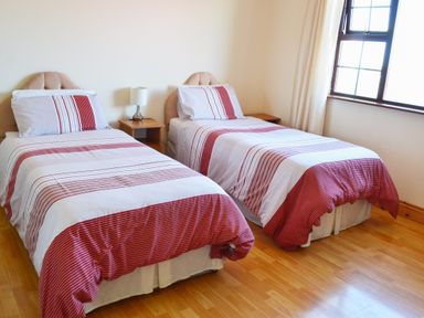 A bedroom with two single beds side by side and a window at Flynn's Cottage in Quilty County Clare