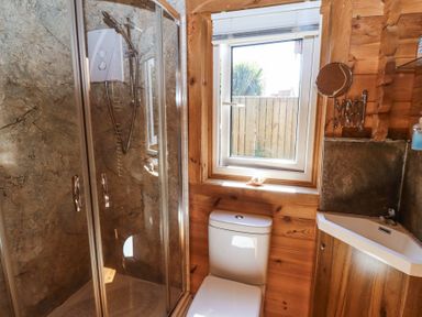 A bathroom with a shower cabin toilet sink and window at Aurora Skies in Cresswell near Morpeth