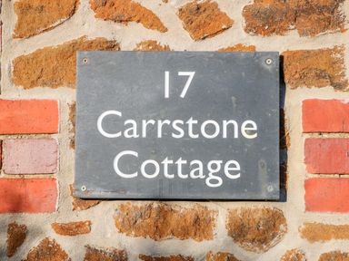 A house number sign reading 17 Carrstone Cottage on a stone and brick wall at Carrstone Cottage Heacham