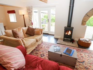 A living room with a wood stove and seating area at Gallow Law Cottage Bellingham