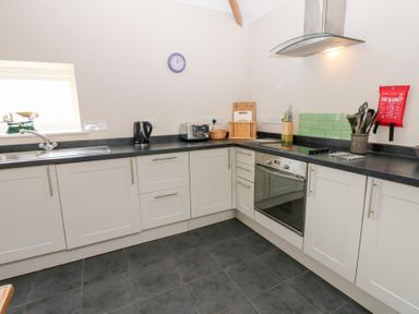 A kitchen with a sink and oven at Gallow Law Cottage Bellingham