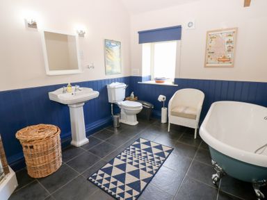 A bathroom with sink, toilet, and bath tub at Gallow Law Cottage in Bellingham