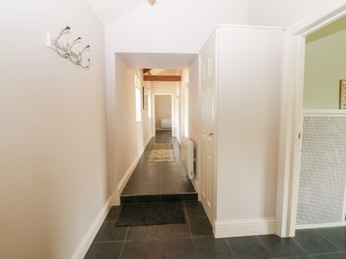 A hallway with coat hooks and a door at Shepherds Burn Cottage in Bellingham