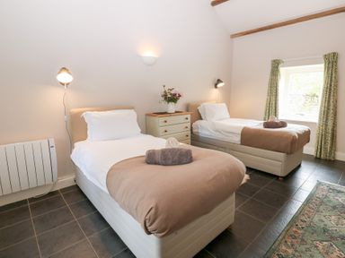 A bedroom with two beds and a dresser at Shepherds Burn Cottage in Bellingham